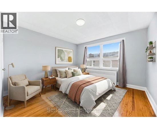 A bedroom with a bed, chair, and window.