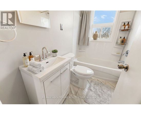 A white bathroom with a tub, toilet, and sink.