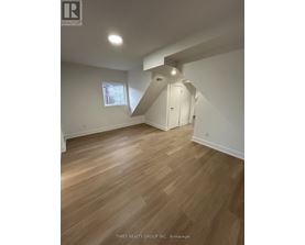 A room with wooden flooring and a window.