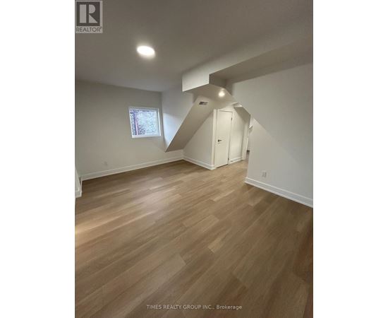 A room with wooden flooring and a window.