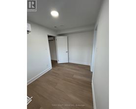 A room with a white door and a wooden floor.