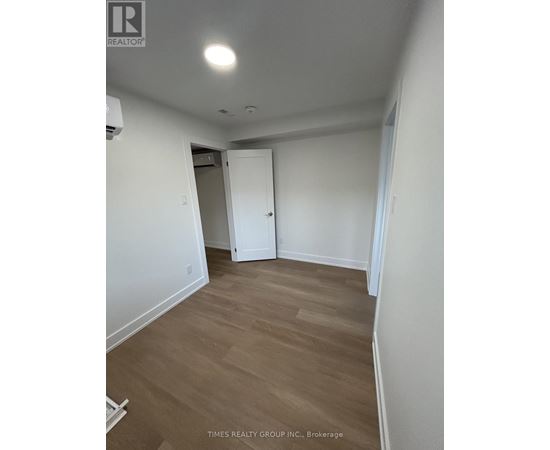A room with a white door and a wooden floor.
