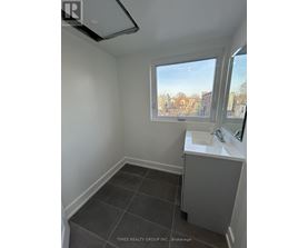 A bathroom with a window overlooking a cityscape.