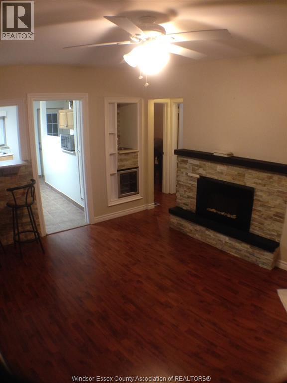 A living room with a fireplace and wood flooring.