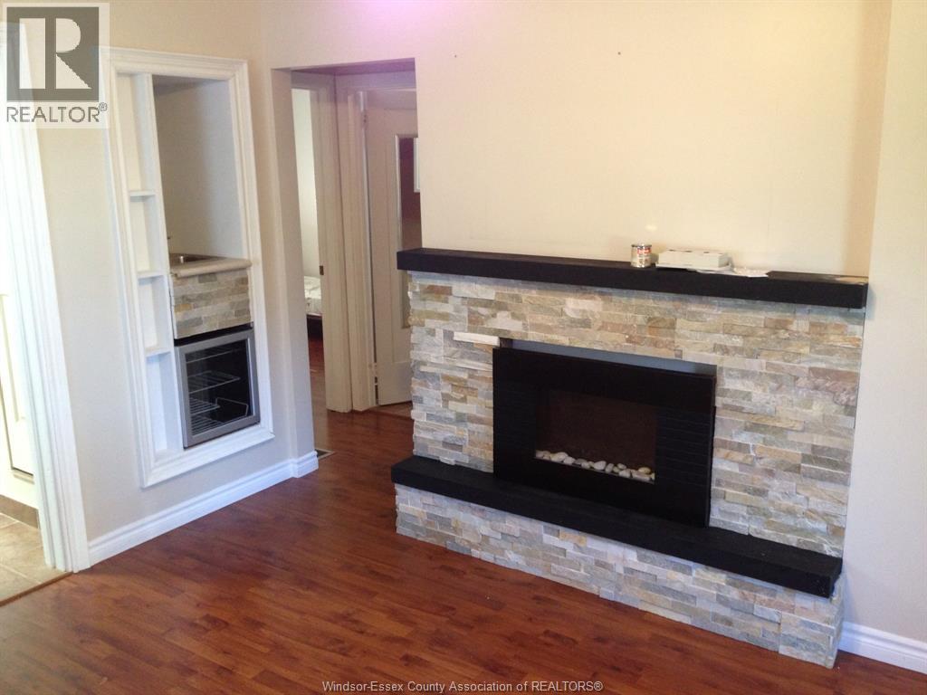 A living room with a stone fireplace and hardwood floors.