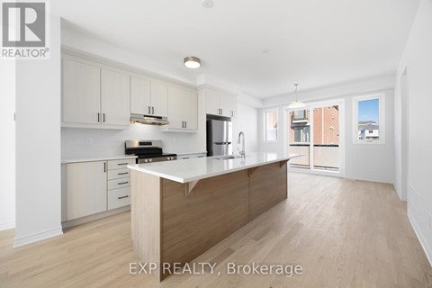 A kitchen with white cabinets and a wooden island.