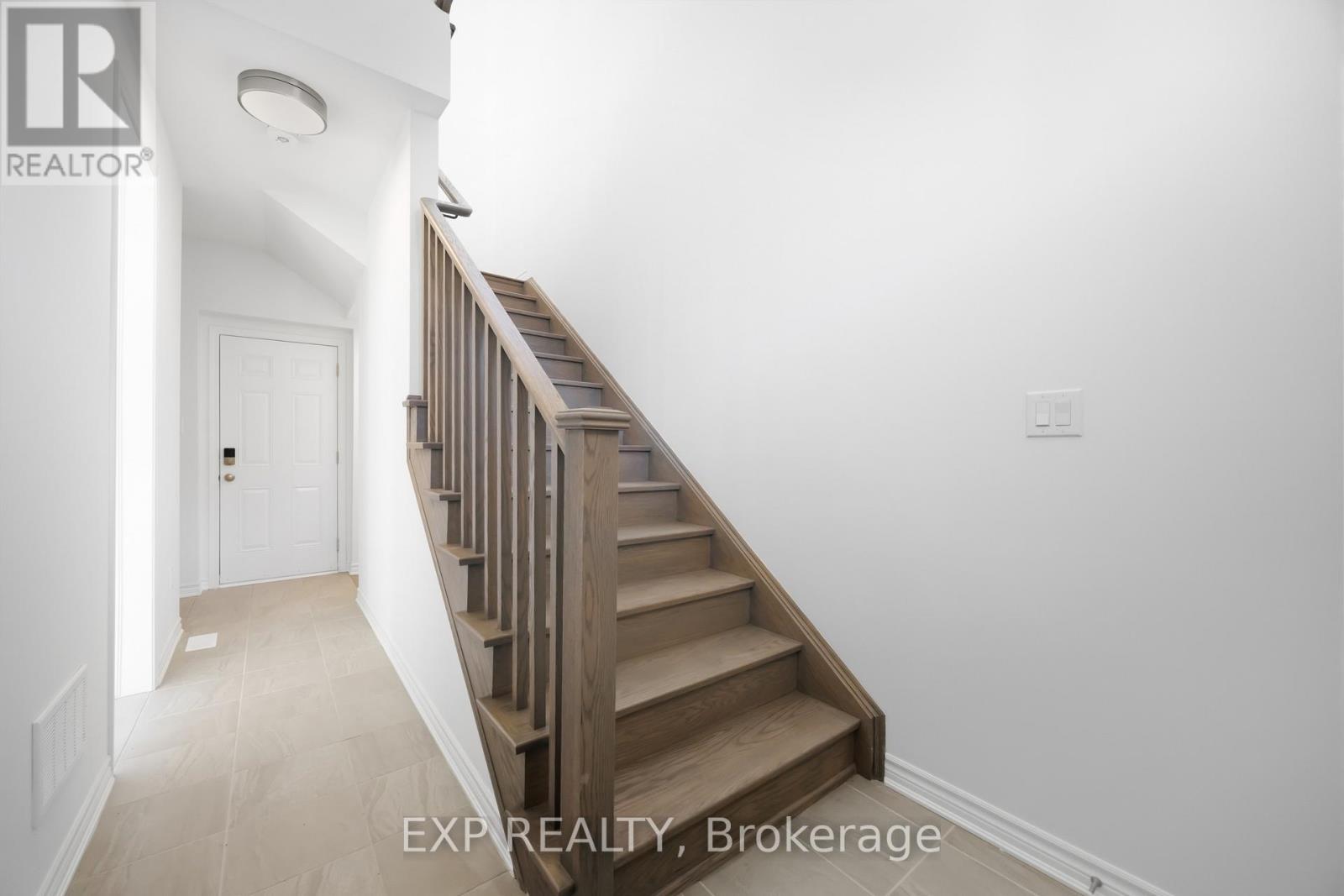 A staircase in a house with EXP REALTY, Brokerage written on the wall.