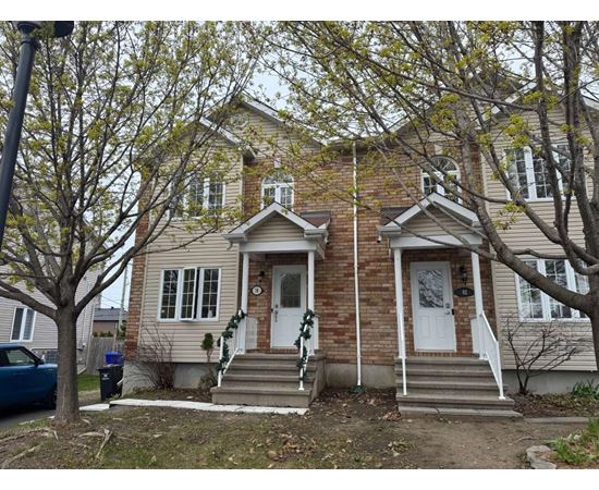A two-story house with a white door and a small porch.