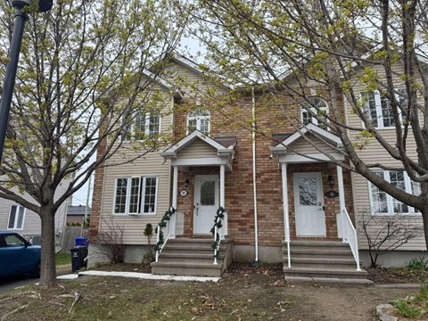 A two-story house with a white door and a small porch.