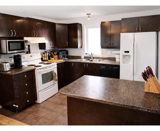 A kitchen with brown cabinets and a white fridge.