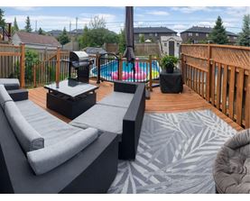 A backyard with a hot tub and a deck.