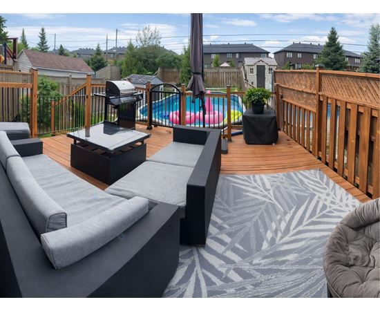 A backyard with a hot tub and a deck.