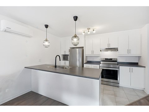 A modern kitchen with a stainless steel island and white cabinets.