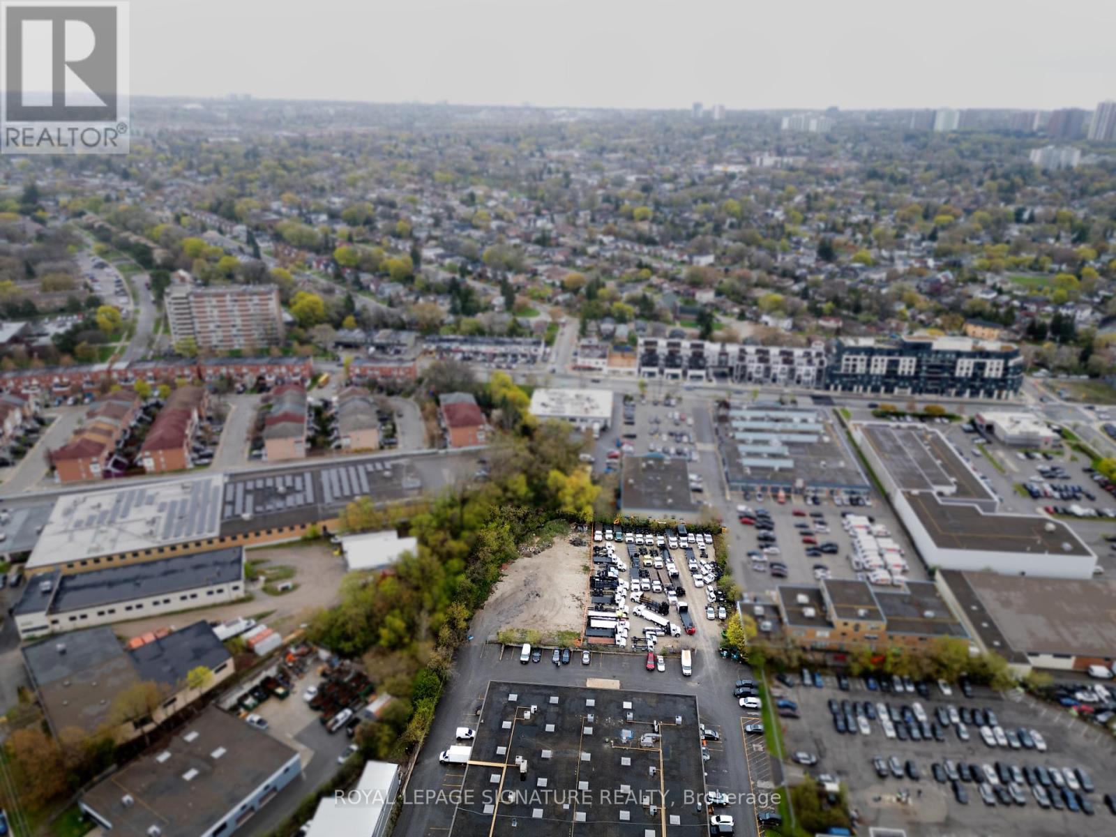 An aerial view of a city with a large parking lot in the foreground.