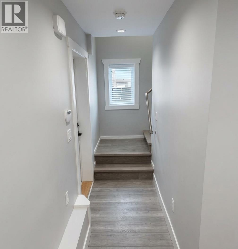 A hallway with a staircase leading to a window.