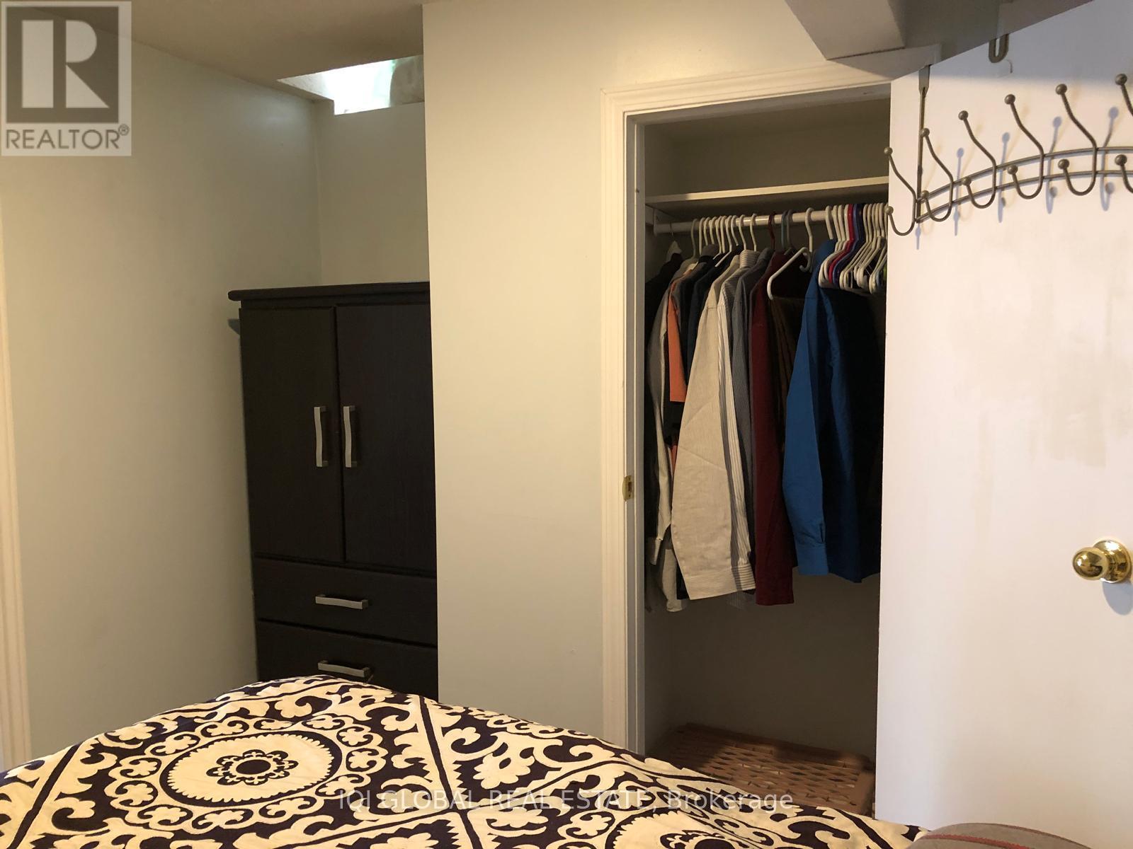 A bedroom with a black and white patterned bedspread and a black wardrobe.
