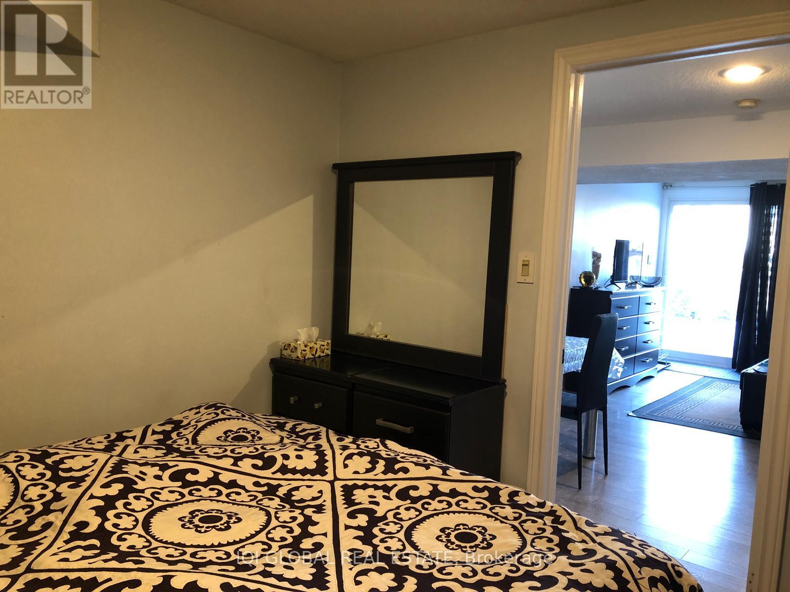 A bedroom with a black and white patterned bedspread.