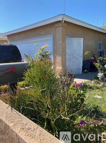 A house with a white door and a car parked in front.