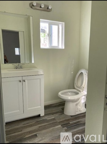 A white toilet in a bathroom with a cabinet and mirror.