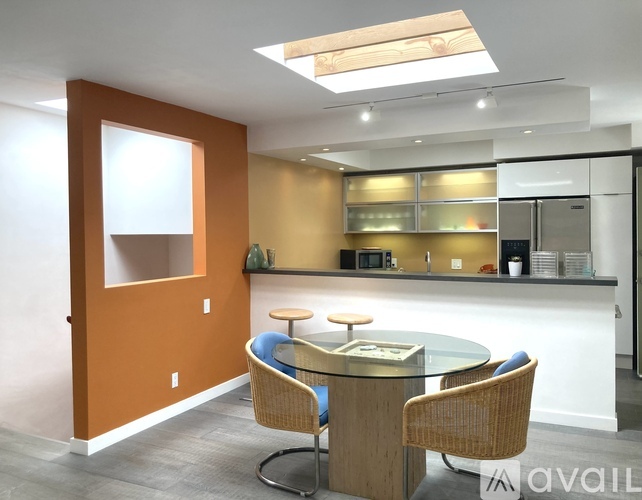 A modern kitchen with a glass table and chairs.