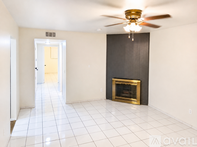 A living room with a fireplace and a ceiling fan.
