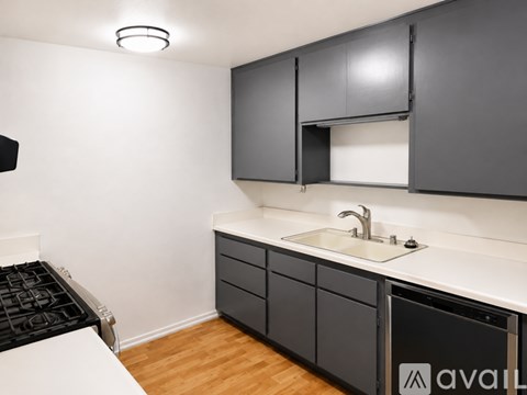 A kitchen with black cabinets and a white countertop.
