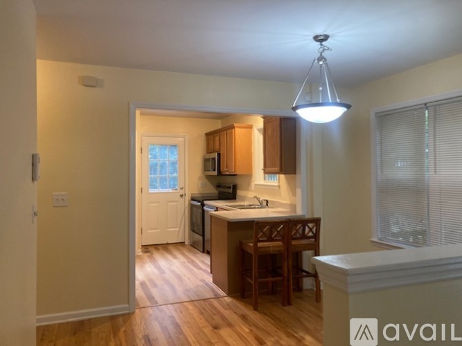 A kitchen with wooden floors and a white ceiling.