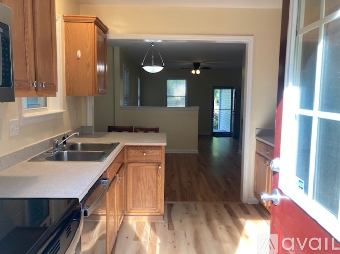 A kitchen with wooden cabinets and a stainless steel dishwasher.