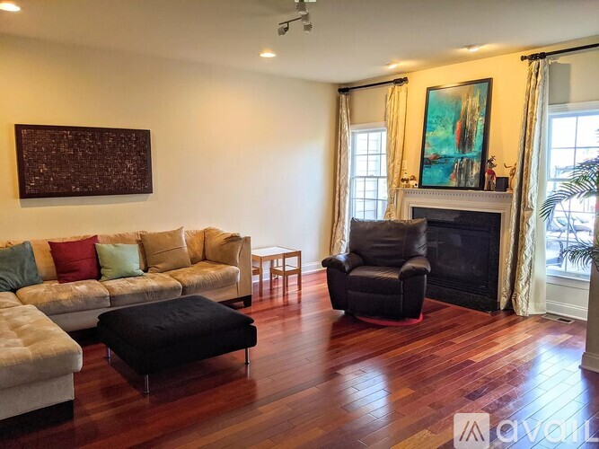 A living room with a fireplace and a painting on the wall.