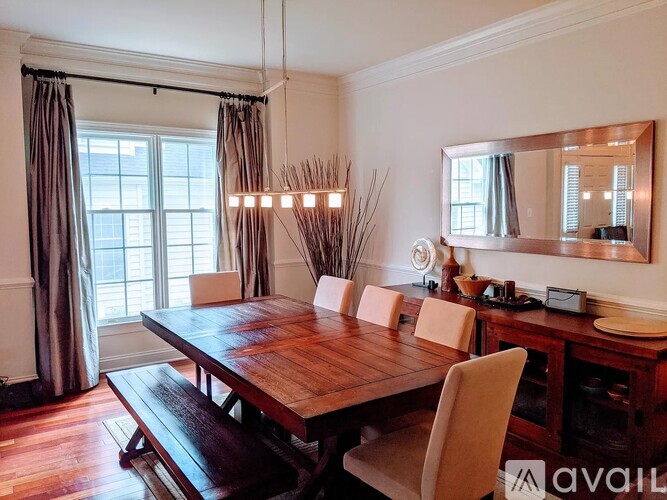 A dining room with a wooden table and chairs.