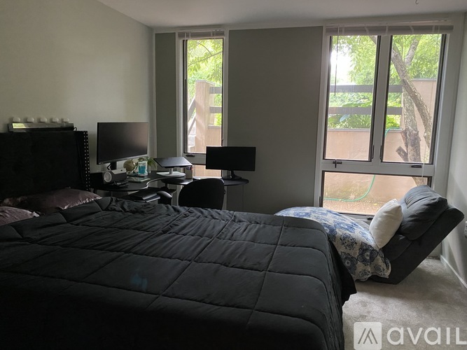 A bedroom with a large bed and a desk with a computer monitor.