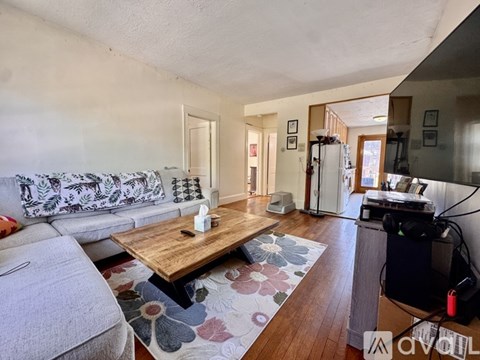 A living room with a grey sofa and a wooden coffee table.