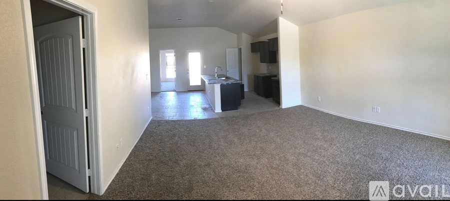 A carpeted room with a door and a window.