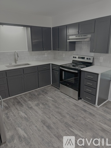 A kitchen with a stove top oven and a sink.