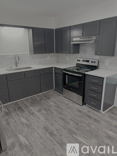A kitchen with a stove top oven and a sink.
