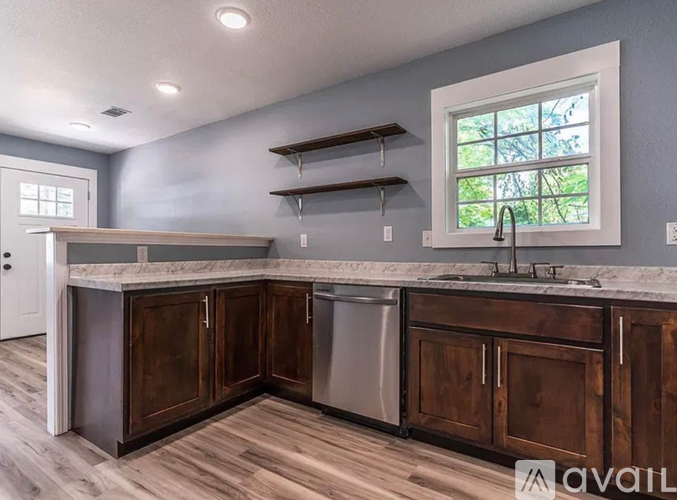 A kitchen with wooden cabinets and a marble countertop.