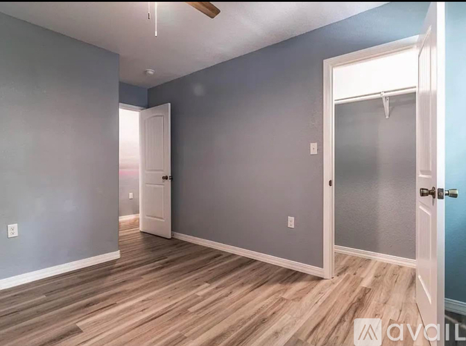A room with a wooden floor and a ceiling fan.