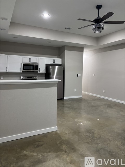 A room with a ceiling fan and wooden flooring.