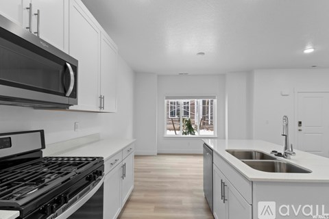 A modern kitchen with white cabinets and a stainless steel stove top oven.