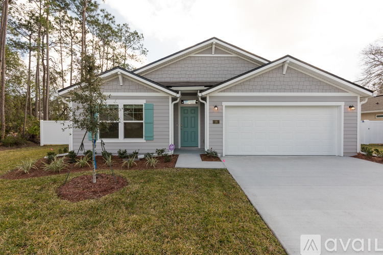 A house with a grey roof and a white garage door.