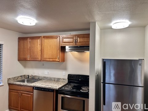 A kitchen with wooden cabinets and a stainless steel refrigerator.