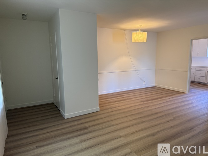 A bedroom with a large bed and a window with curtains.