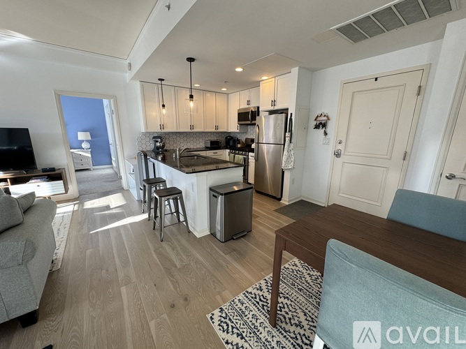 A modern kitchen with a dining table and a couch.