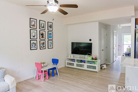 A living room with a television, a sofa, and a table with chairs.