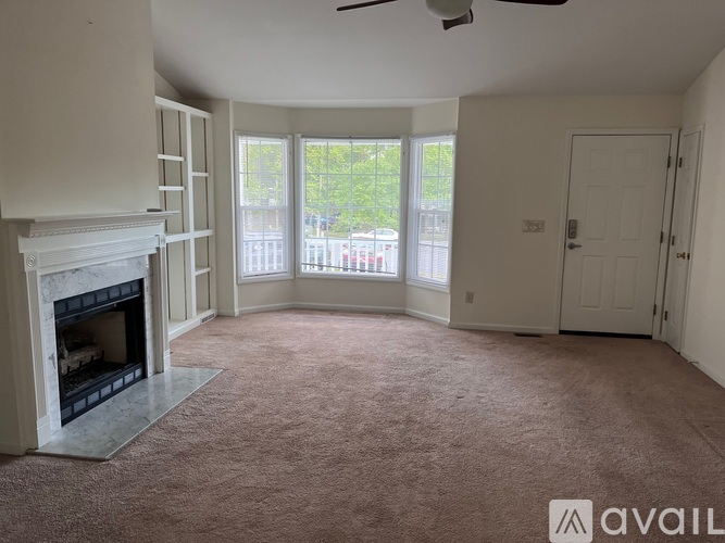 A living room with a fireplace and carpeted floor.