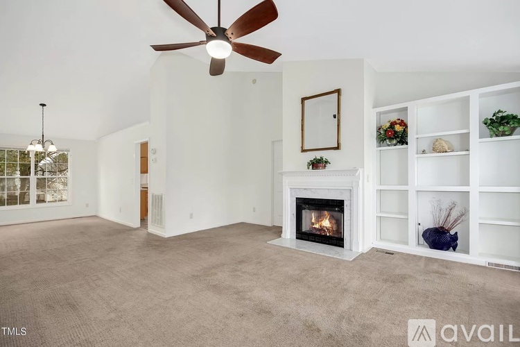 A living room with a fireplace and a ceiling fan.