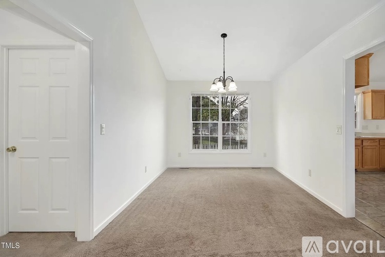 A room with a carpeted floor and a window with bars on it.