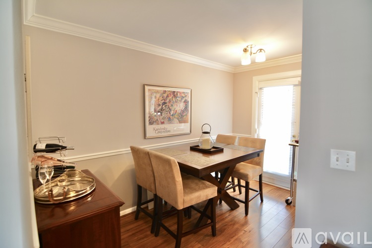 A dining room with a wooden table and chairs.