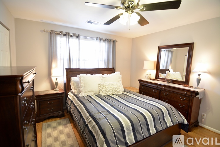 A bedroom with a bed, dresser, and mirror.