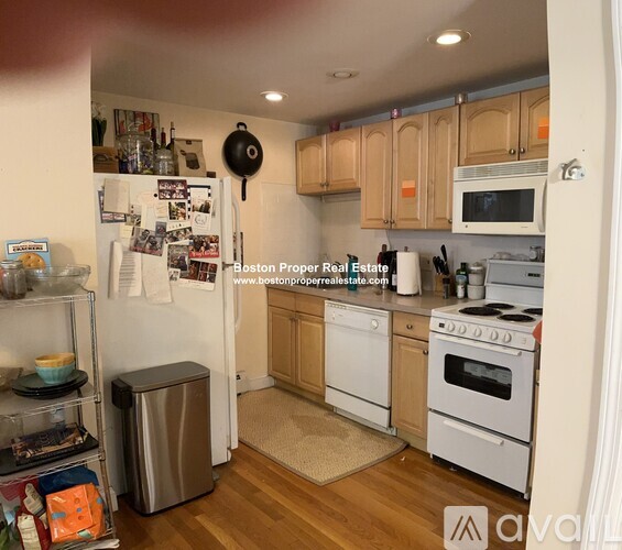 A kitchen with wooden cabinets and white appliances.